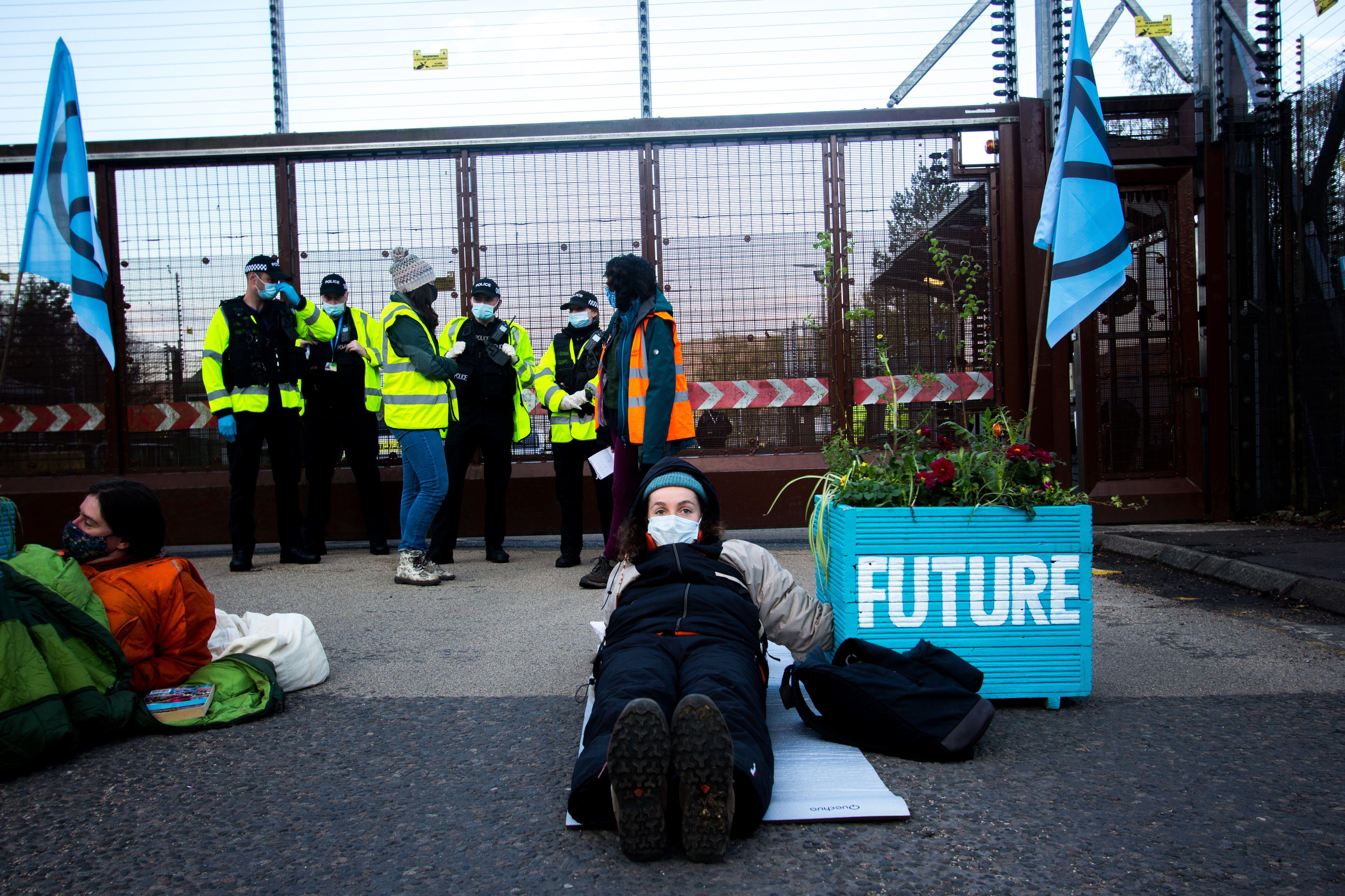 Cover image: Extinction Rebellion protestors outside the base earlier on Friday (Picture: PA Images/Alamy Stock Photo).