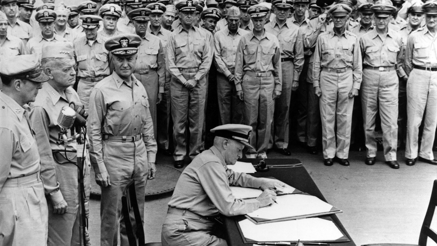 Image shows the Surrender of Japan. Fleet Adm. Chester W Nimitz, US Navy, signs the Instrument of Surrender as a United States representative, on board USS Missouri on 2 September 1945 CREDIT US Navy