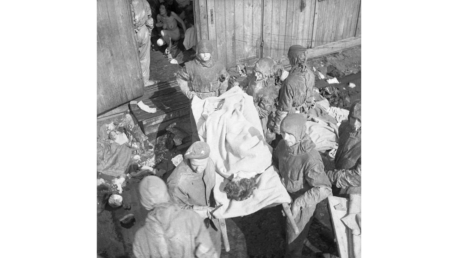 Image ID 2XX6E14 British soldiers wearing hazmat suits as they take the dead and sick from the barracks after the liberation of Bergen-Belsen concentration camp NO REUSE CREDIT CBW Alamy Stock Photo