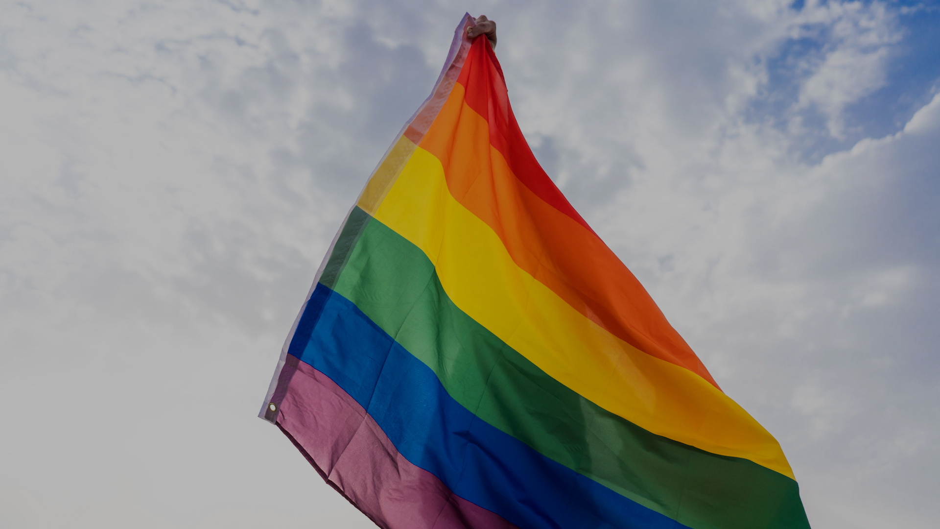Person with LGBT flag covering his body