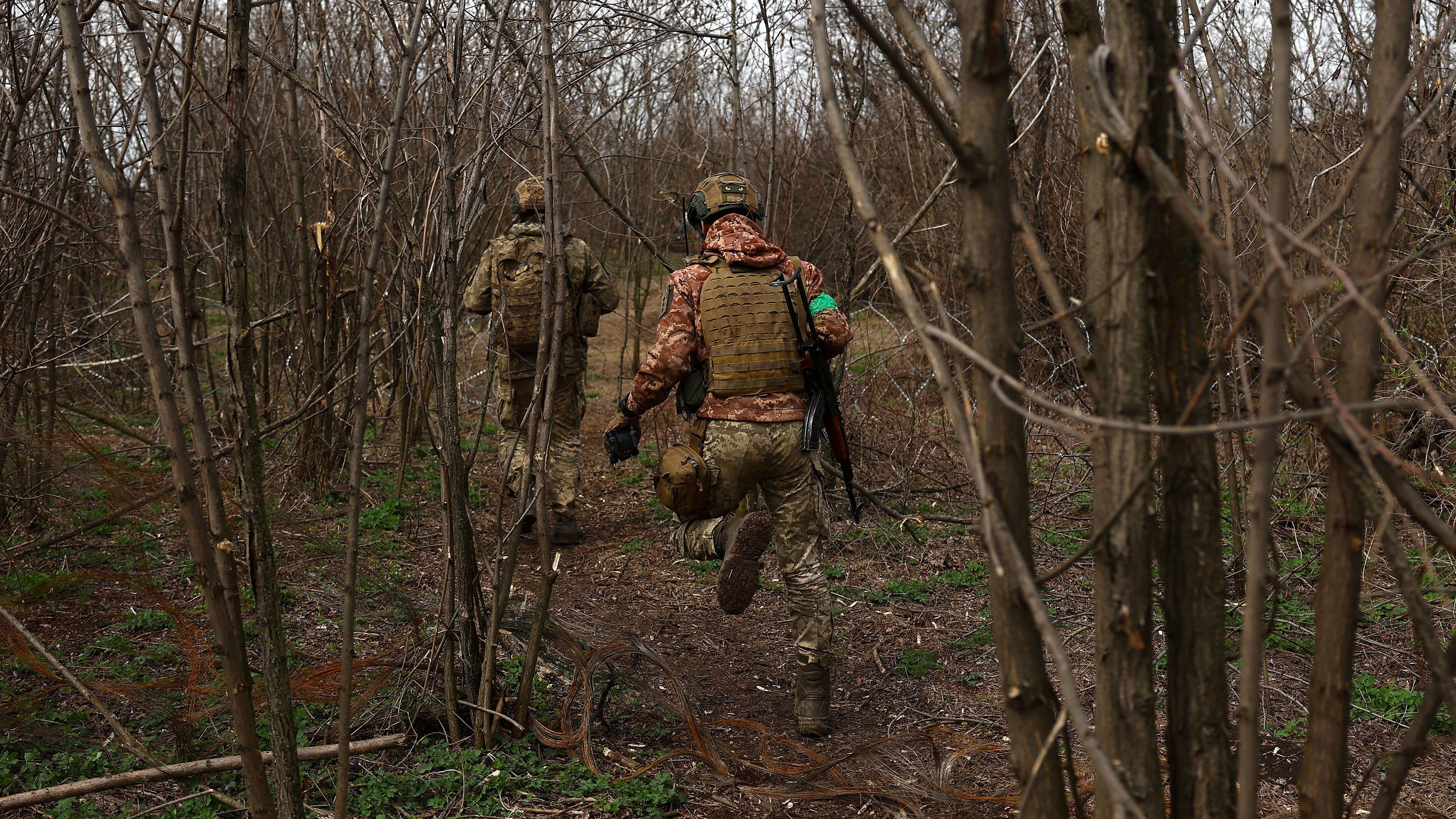 Image ID 2PK330K Ukrainian service members run between positions at the frontline, region of Bakhmut 05042023 CREDIT Reuters, Alamy EXP 12042024.jpg