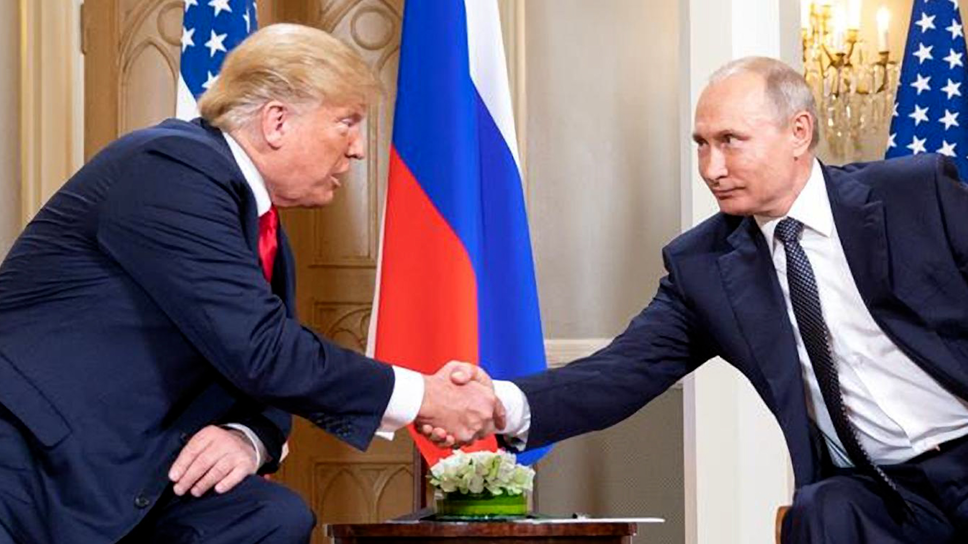 Russian President Vladimir Putin shakes hands with Donald Trump