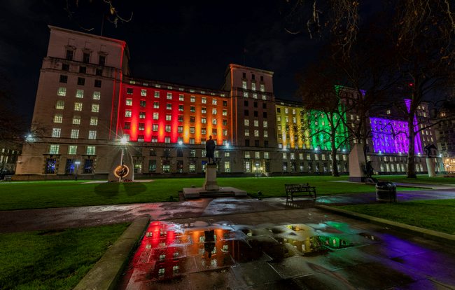 Image of the Ministry of Defence Main Building HQ in London, illuminated with rainbow colours to mark 20 years since lifting of LGB military ban. Credit: Sgt Peter Devine, Crown Copyright