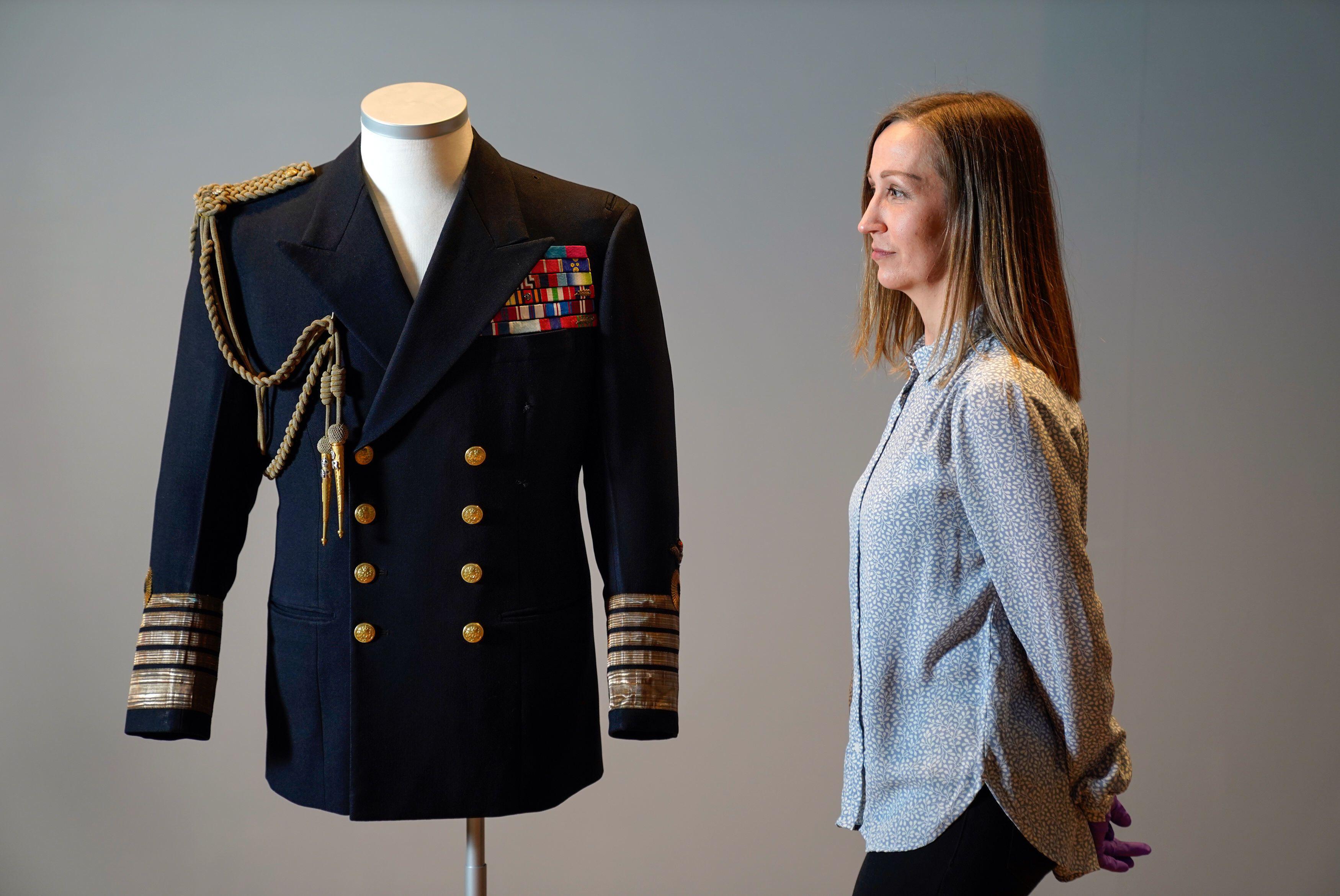 Kate Braun, curator at the National Museum of the Royal Navy, looks a naval uniform which once belonged to the Duke of Edinburgh as it goes on display