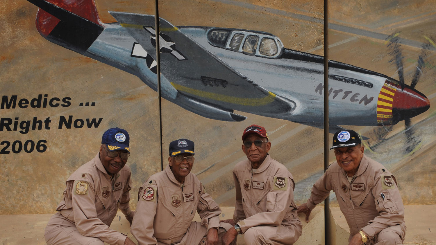 L to R Tuskegee Airmen Maj George Boyd, Lt Col Alexander Jefferson, Staff Sgt Philip Broome and Lt Col James Warren pose in front of barrier art in Iraq depicting a Red Tail P-51 in 2009 CREDIT US Air Force