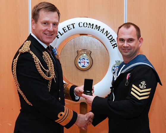 Vice Admiral Ben Key CBE presents Leading Logs Andrew Gill with the Queen's Commendation for Valuable Service.