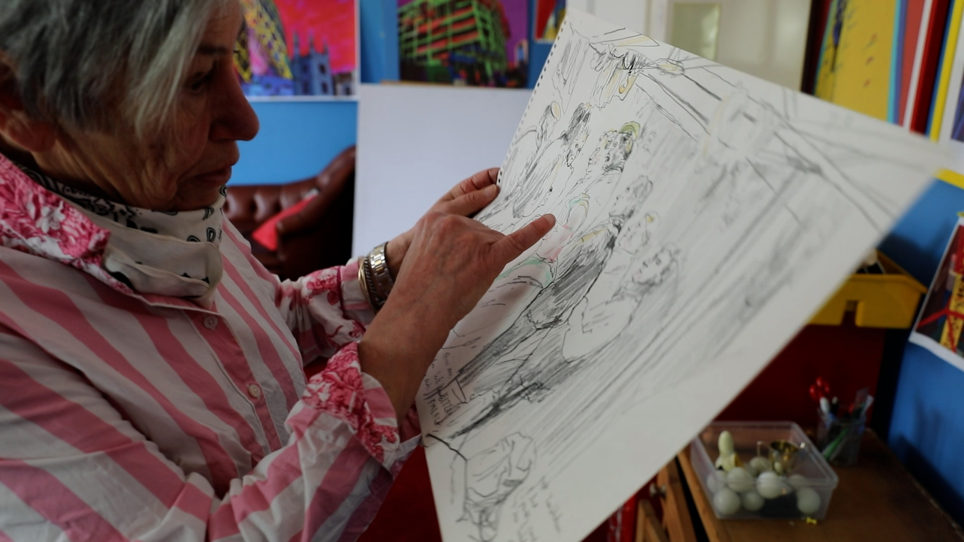 An artist holds up her work.
