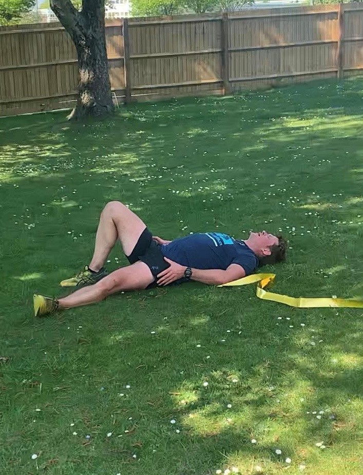 Lt. Camm recovers on the grass following his 26.2 mile run around the garden of the Officers' Mess. Credit: RCamm