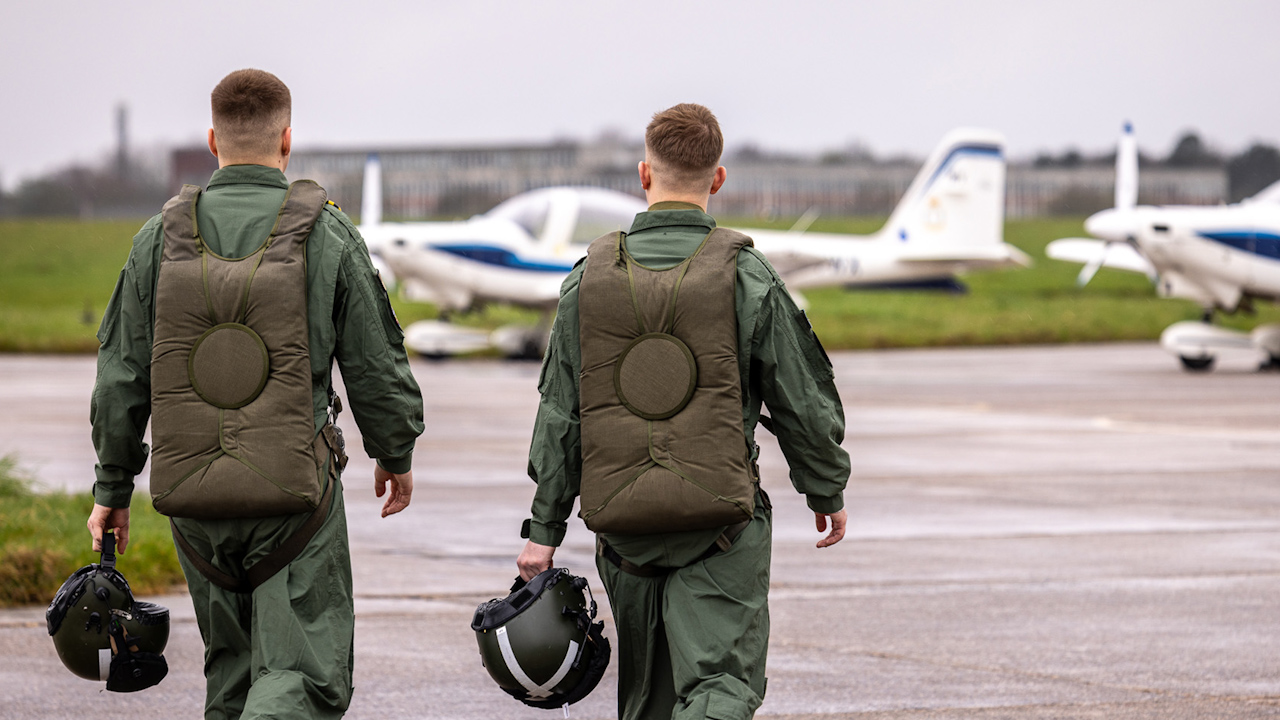 Two Ukrainian pilots walking towards the RAF's training aircraft, the Grob Tutor T.Mk 1 aircraft (Picture: MOD/ Royal Air Force).