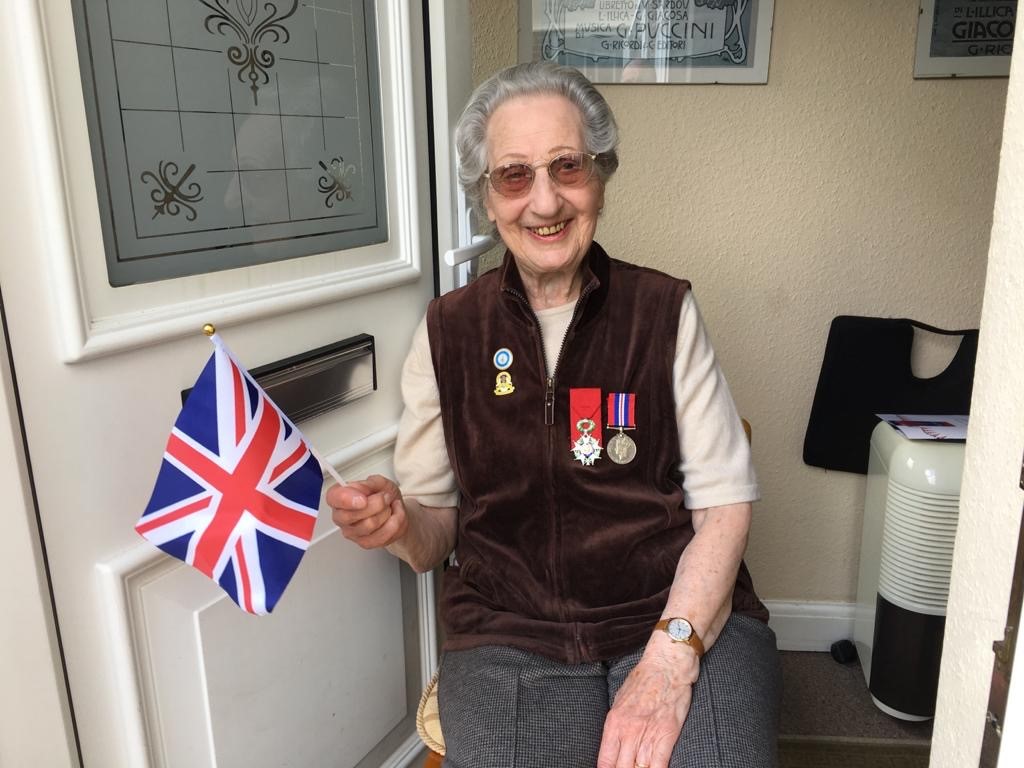 Marie Scott waving a Union Jack for VE Day. Credit: Ian Parsons.