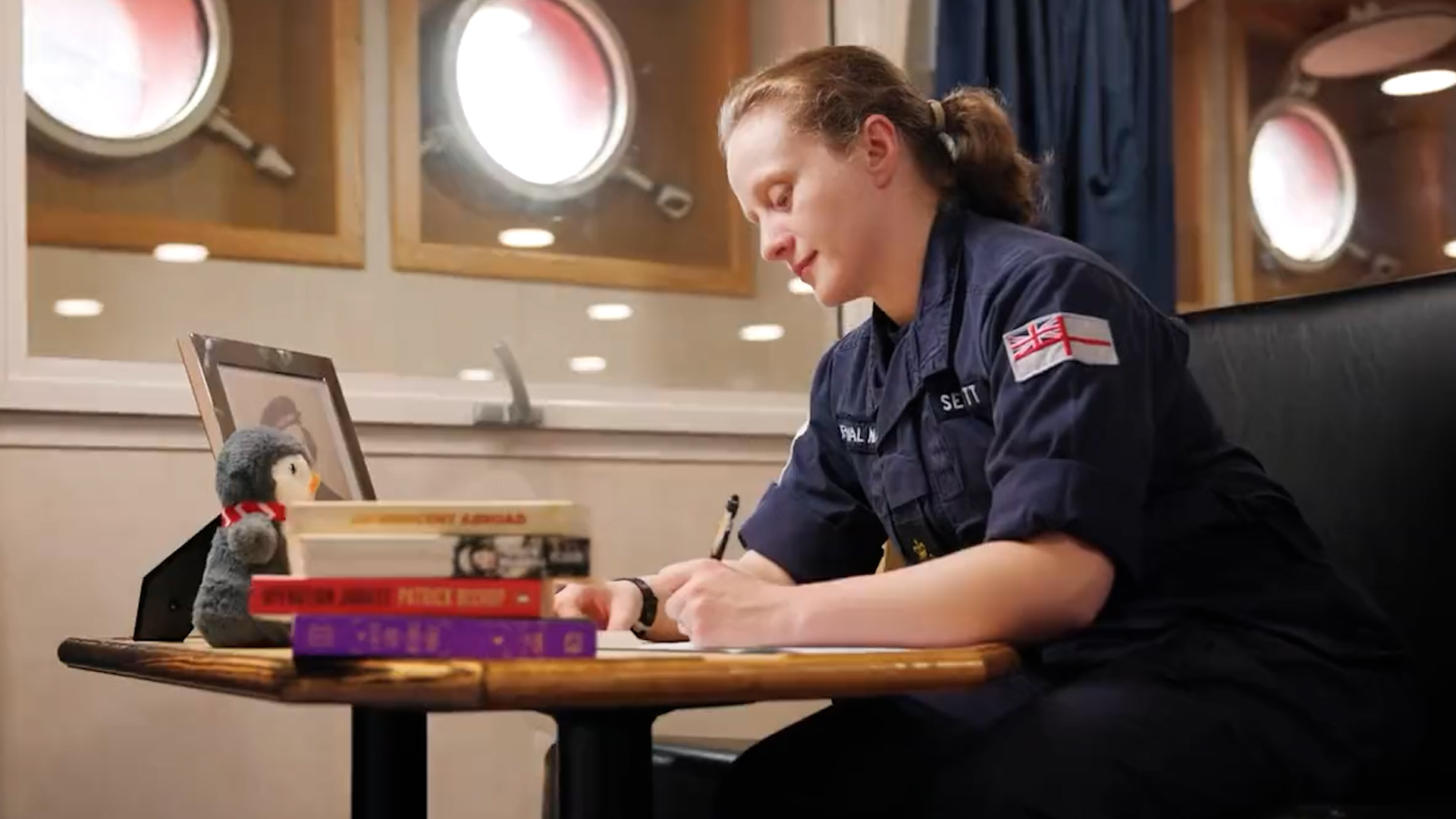 Member of HMS Protector's crew writing a letter to her Wren Grandmother to mark International Women's Day