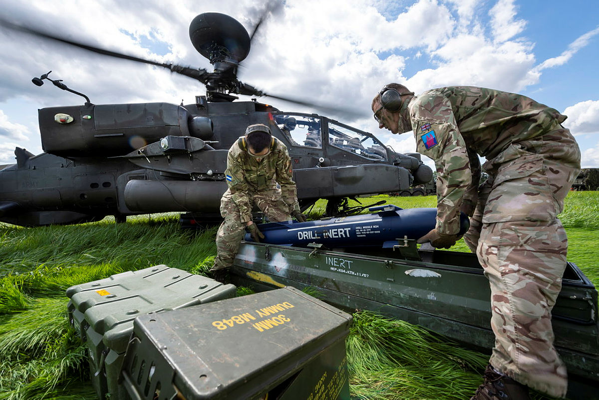 Members of 6 Regiment Army Air Corps load a drill Hellfire missile onto an Apache in 2020