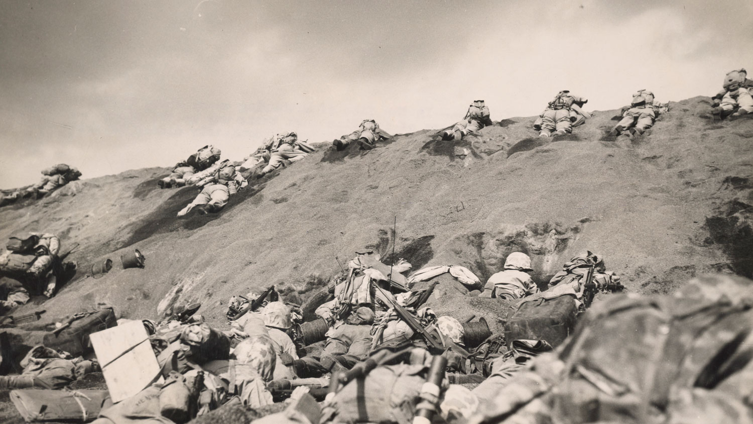 Men from 5th Marine Division work their way up on the steep slope of the beach toward Suribachi Yama CREDIT National Archives and Records Administration