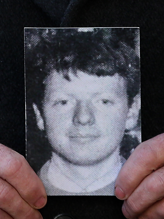 Cover image: Michael McElhone holds a photograph of his brother Paddy McElhone, outside Omagh courthouse (Picture: PA).