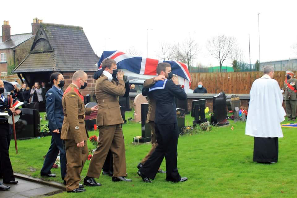 Military pallbearers carry a coffin containing the ashes of 119 reinterred veterans