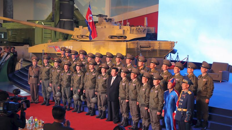 North Korea's leader Kim Jong Un takes pictures with military personnel at the Defence Development Exhibition