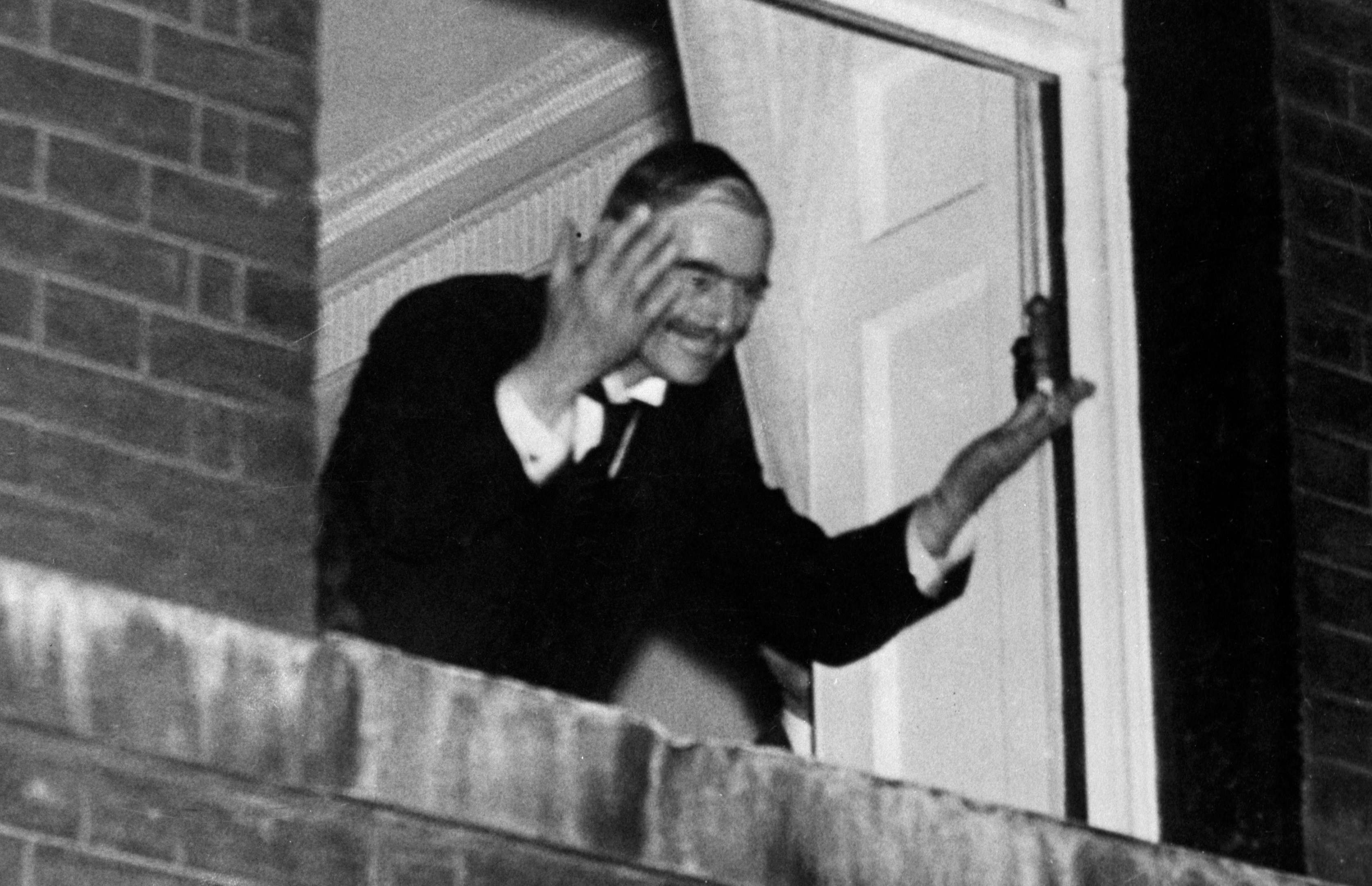 Neville Chamberlain waves to crowds from the window of No.10 after the Munich Agreement was signed. Credit PA 010918