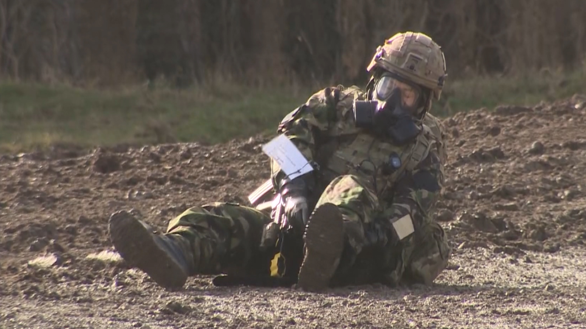 Soldier in CBRN protective gear treats himself during Exercise Toxic Dagger