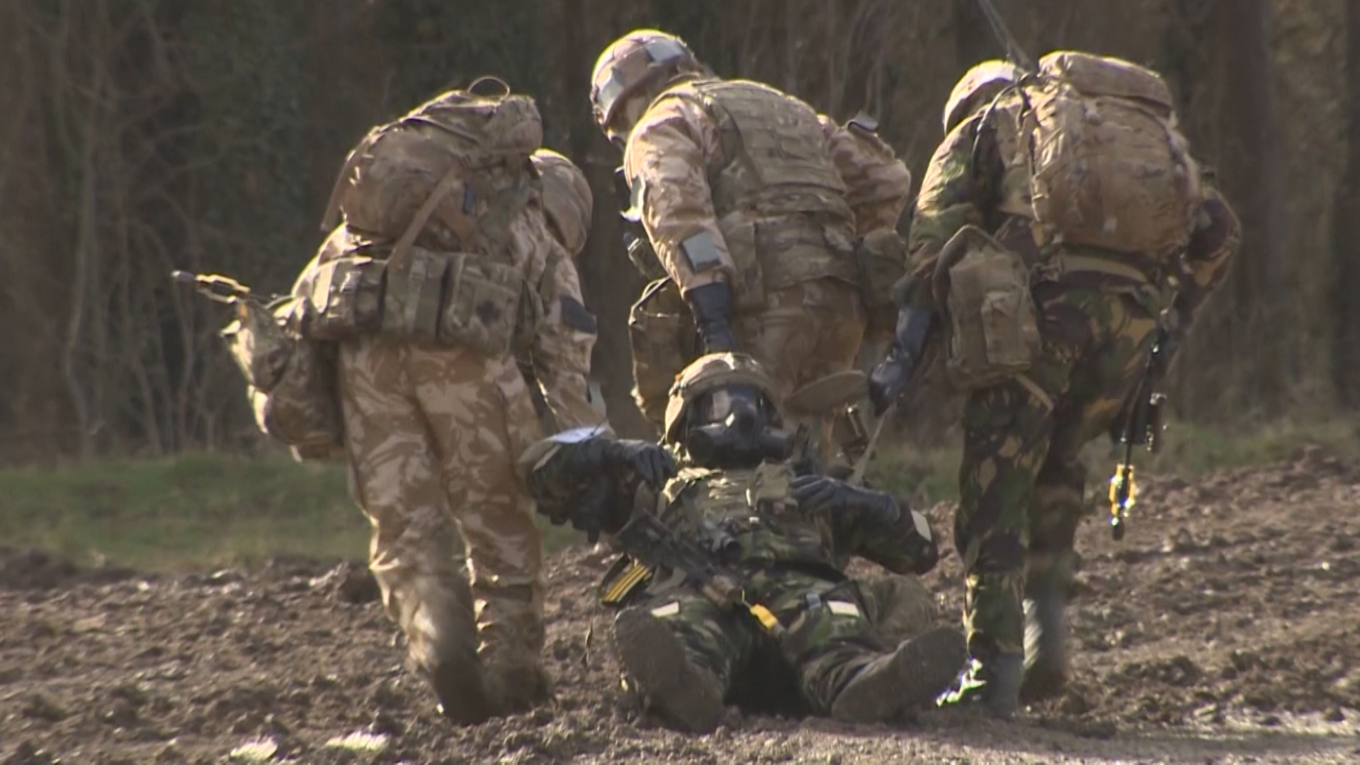 Royal Marines in CBRN gear drag Commando for treatment in Exercise Toxic Dagger