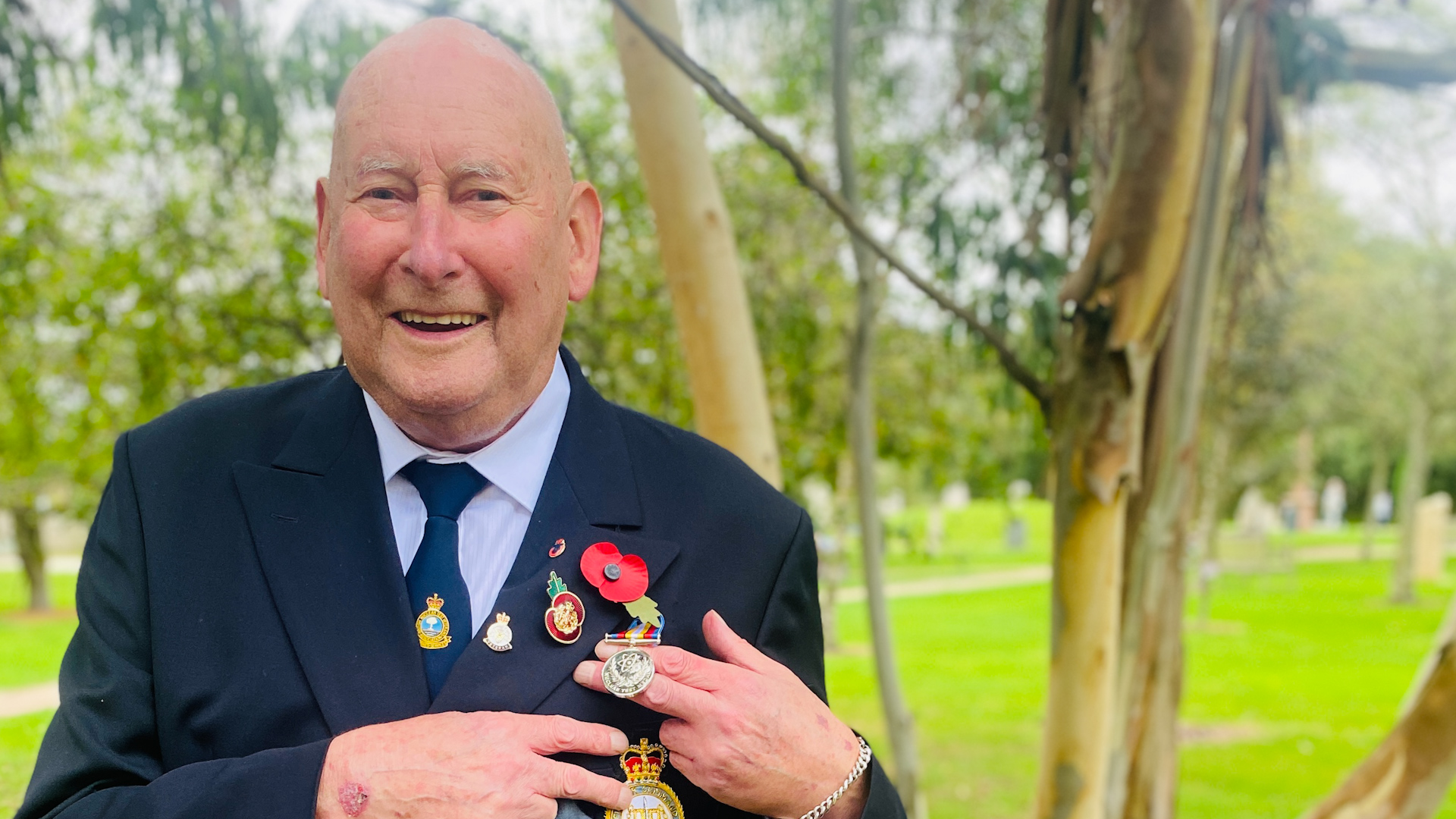 A nuclear test veteran displays his medal at the National Memorial Arboretum.