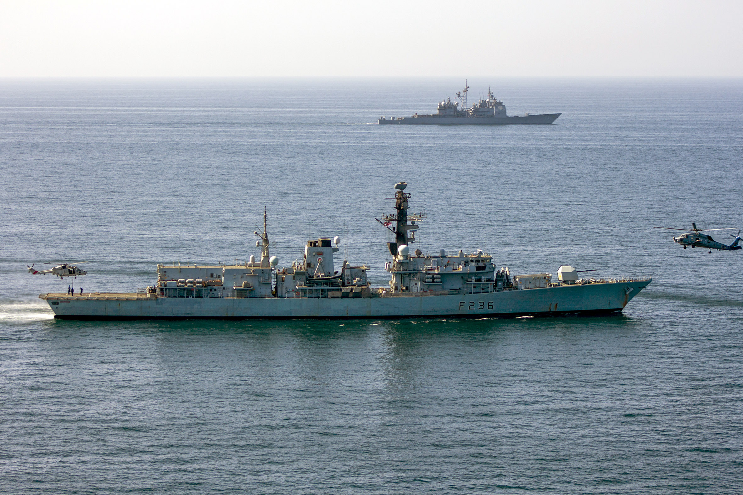 Omani Super Lynx helicopter and US Navy helicopters work with HMS Montrose with cruiser USS Port Royal in the background off the coast of Oman during Exercise Khunjar Hadd DATE UNKNOWN CREDIT ROYAL NAVY