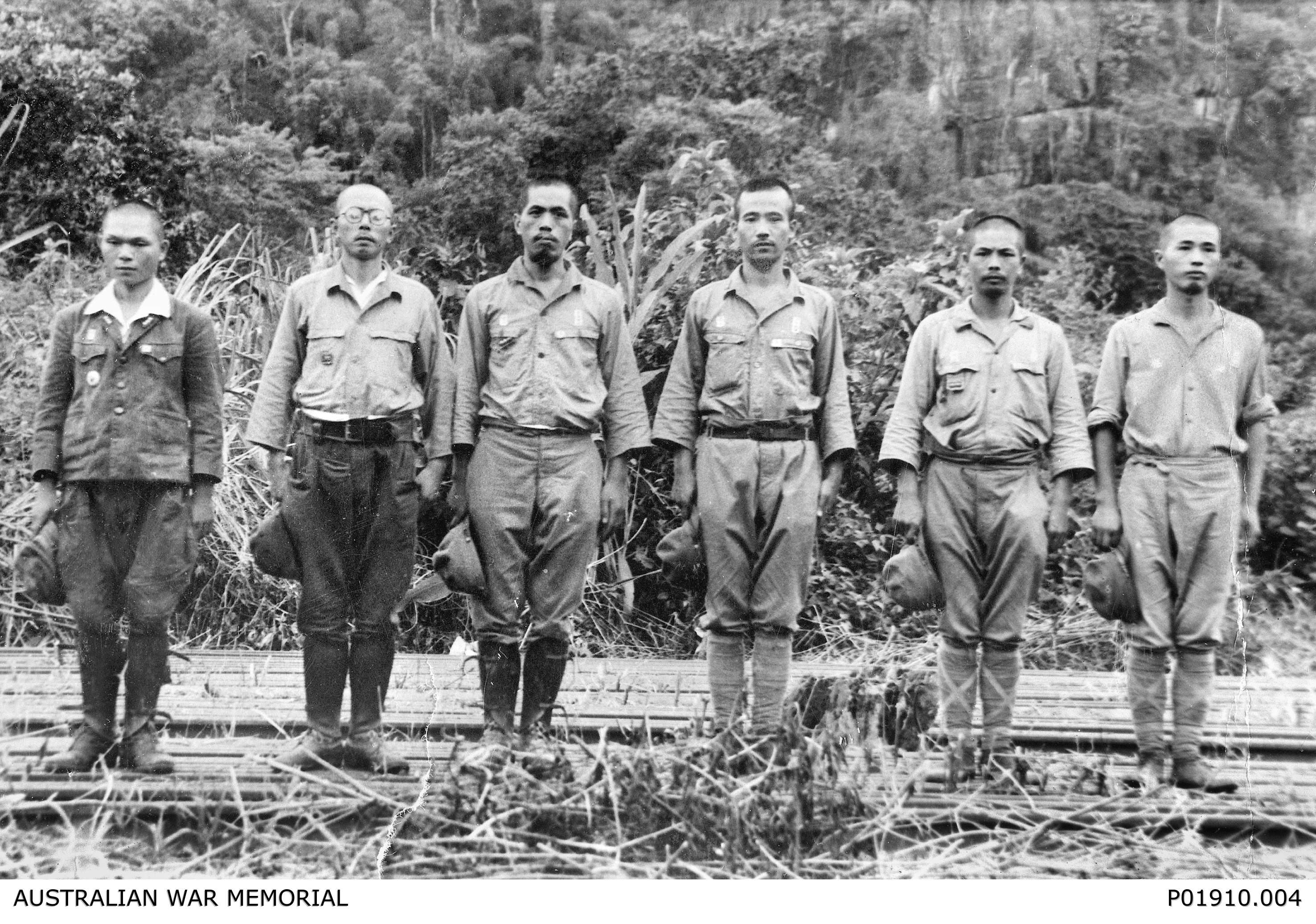 Group portrait of Japanese war crimes suspects, formerly guards at prisoner of war (POW) camps