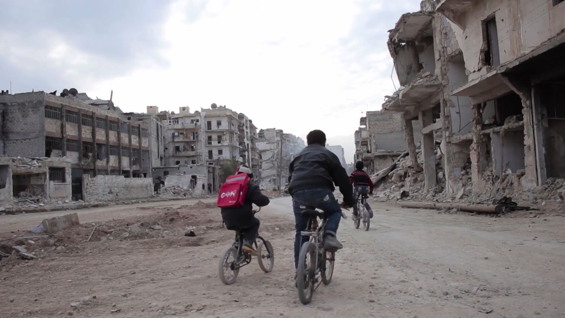 People cycling amid the rubble in Syria (Picture: UNICEF).