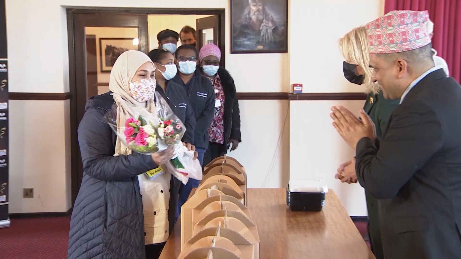 People queue as the 100,000th free meal for key workers from a Nepalese Restaurant is handed out at Royal Artillery Barracks in Woolwich.