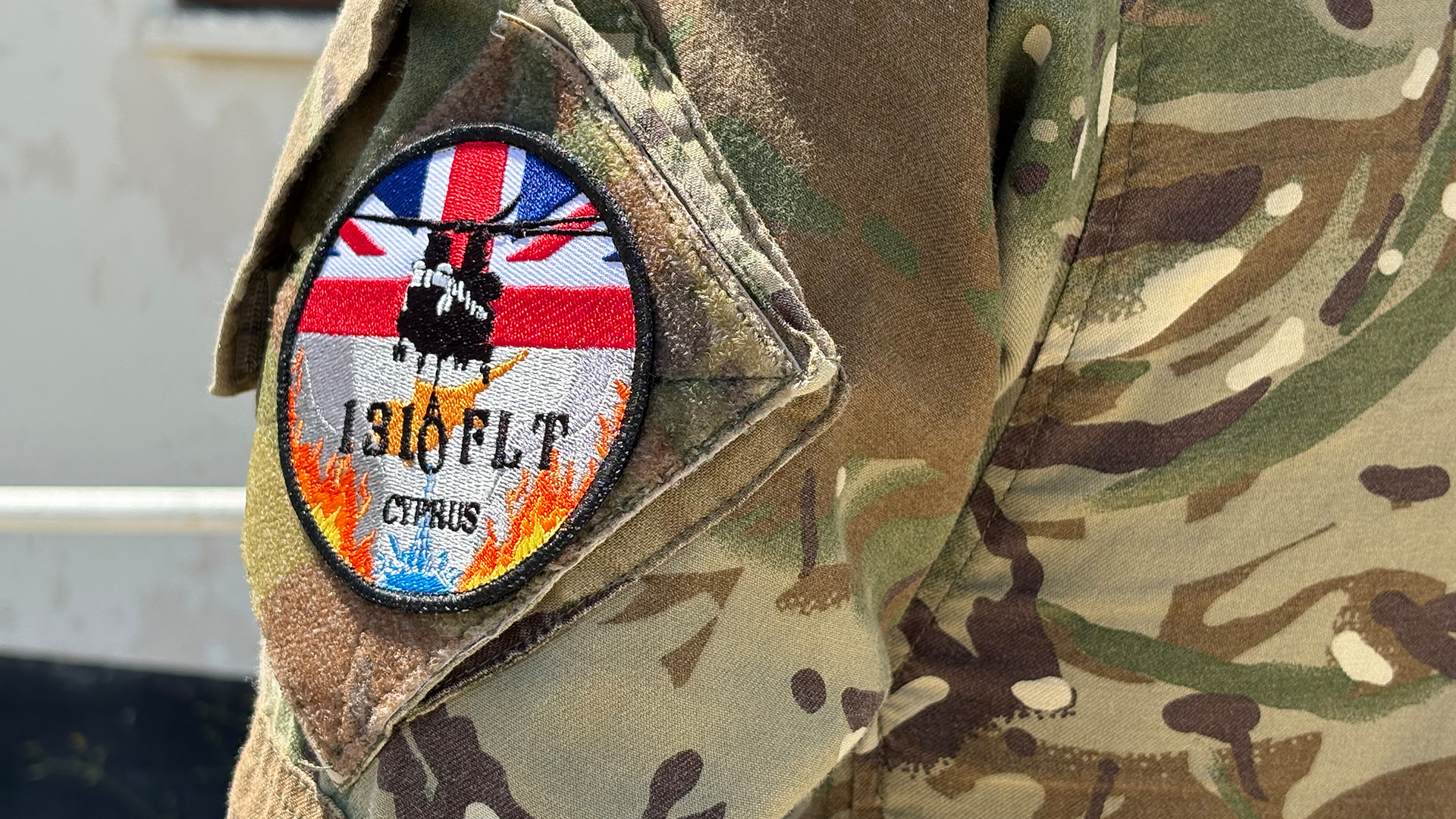 Personnel from 1310 Flight have their own sleeve patch showing a Chinook dump its load of water onto some flames