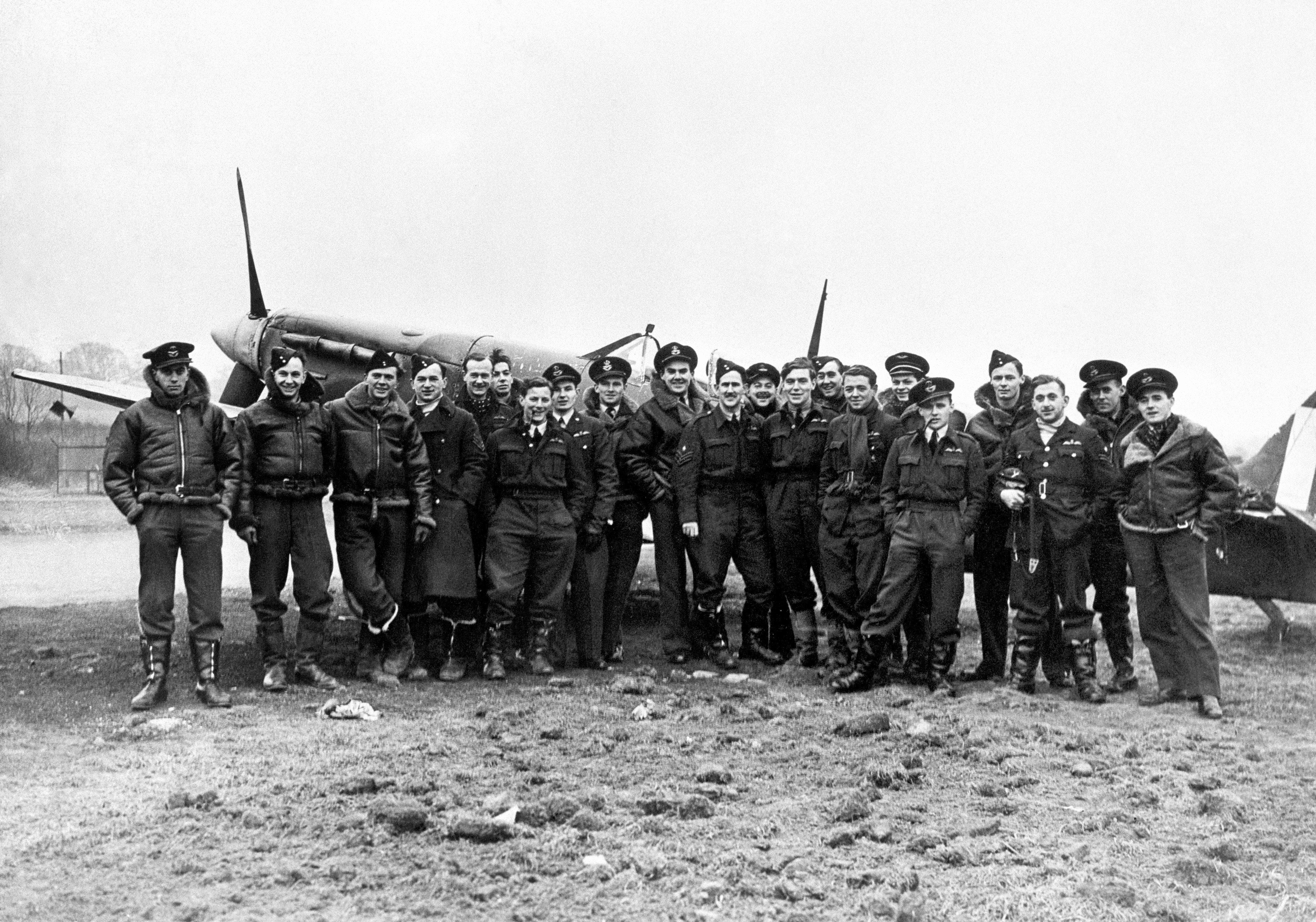 RAF personnel pose in front of a Spitfire - an aircraft that proved vital in protecting Britain's skies during World War Two (Picture: PA).