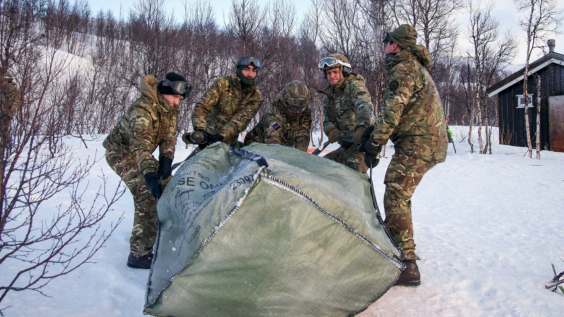 With the load dropped off, the team unpacks the individual bags of logs