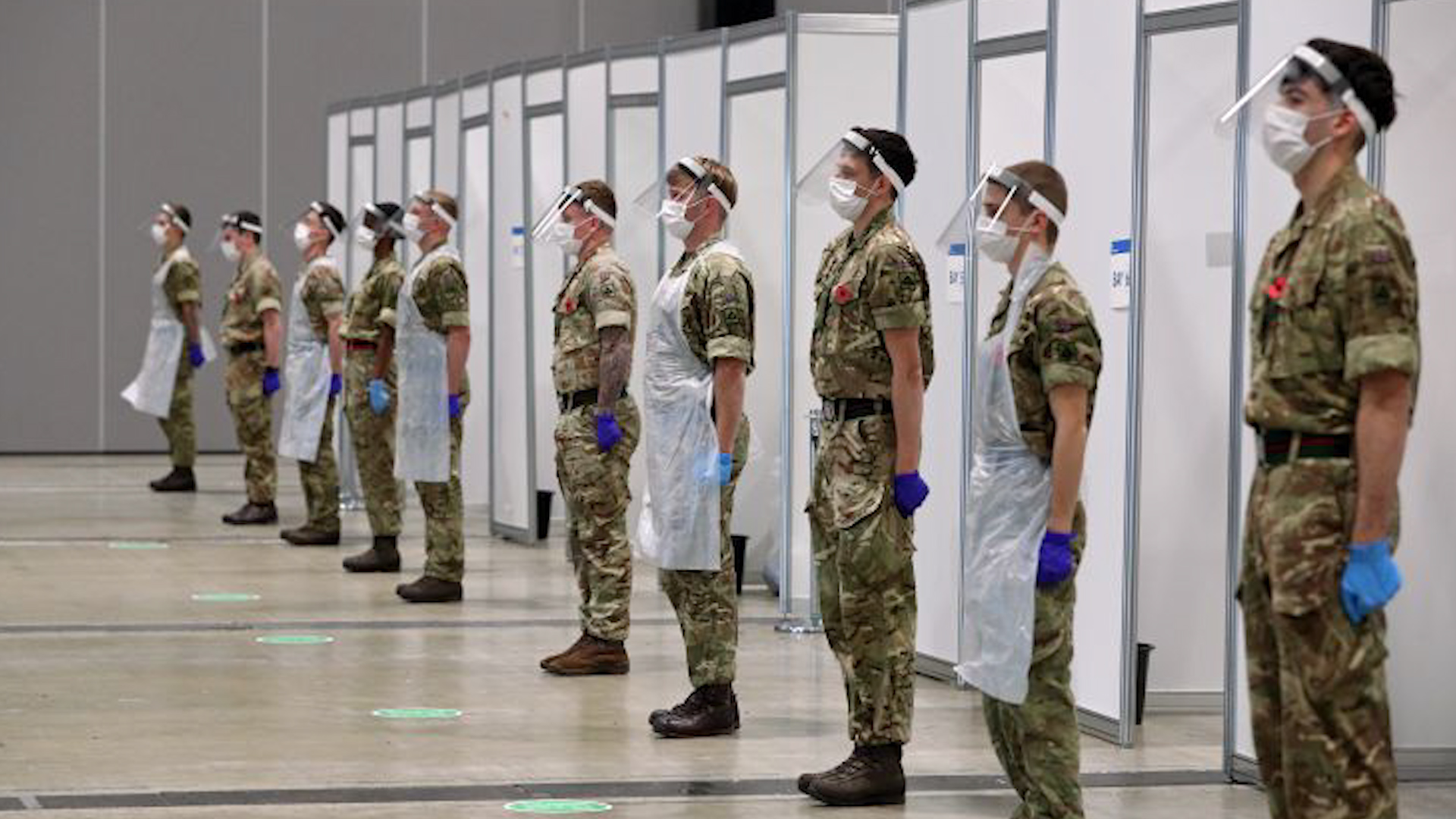 Personnel helping with the mass covid testing on Merseyside stand during a two minute silence at the Arena Convention Centre in Liverpool on Armistice Day (Picture: PA).