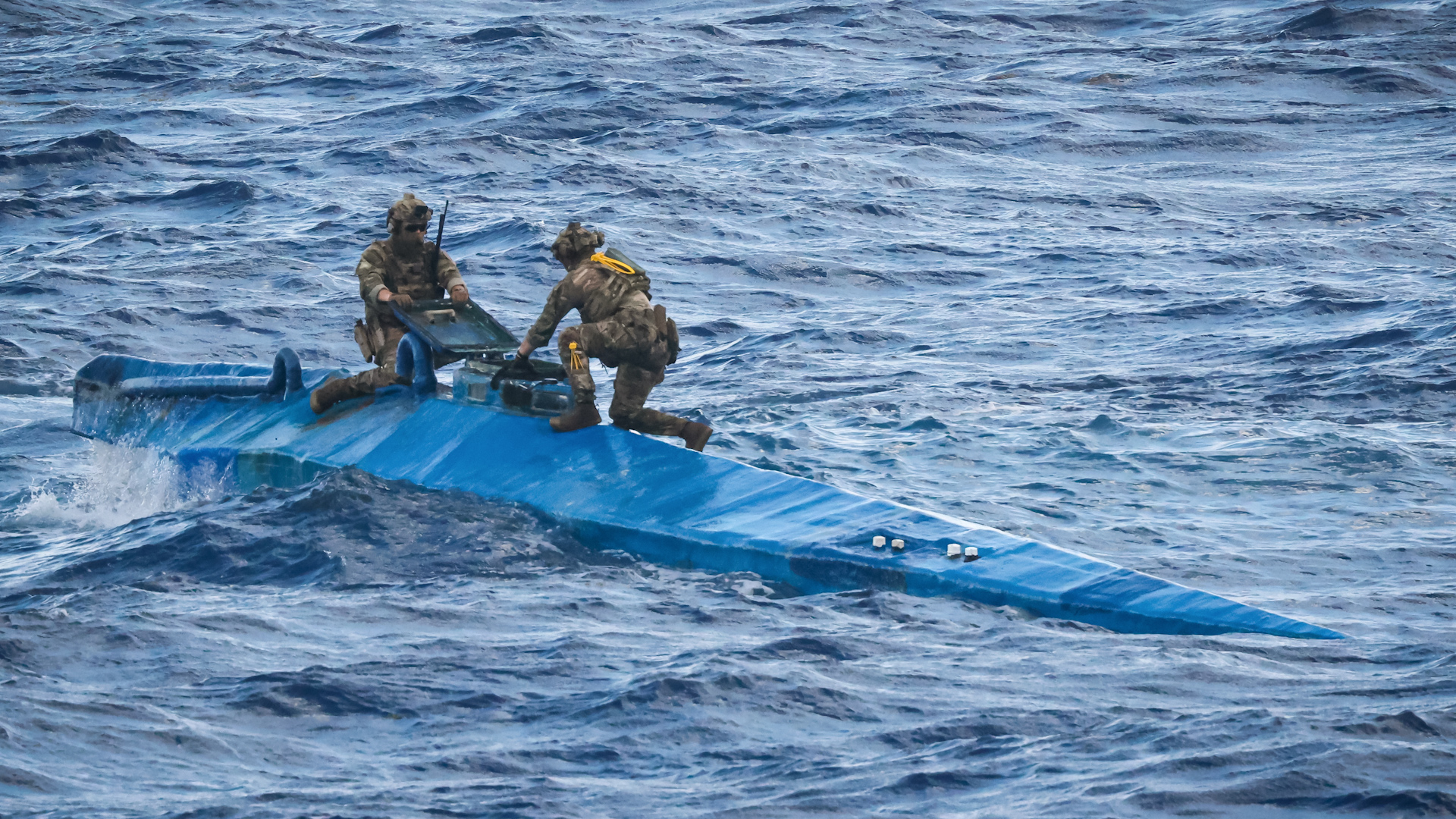 Personnel on the top of a 'narco-submarine', from which HMS Trent seized £160m of cocaine