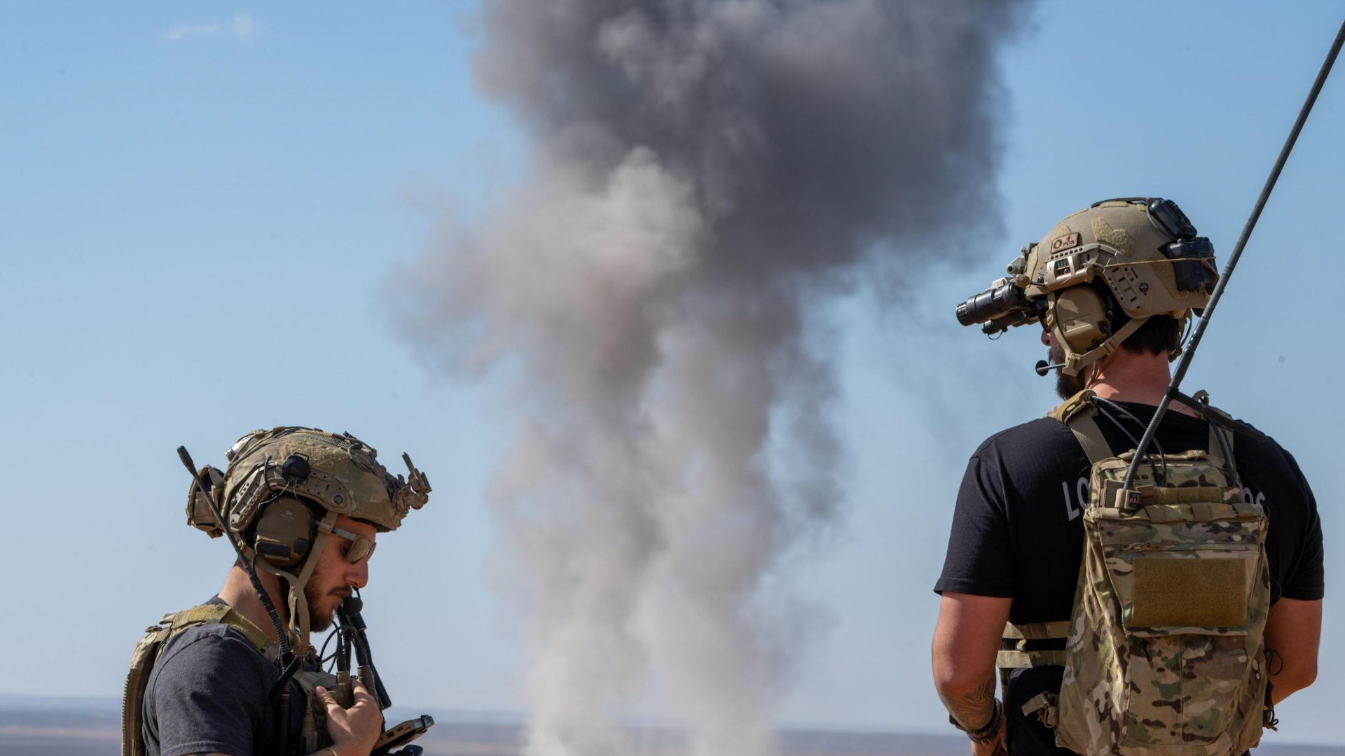Personnel standing near the site of a live munition drop from two US B-52 that took part in a 24 hour flight 190225 CREDIT CENTCOM X