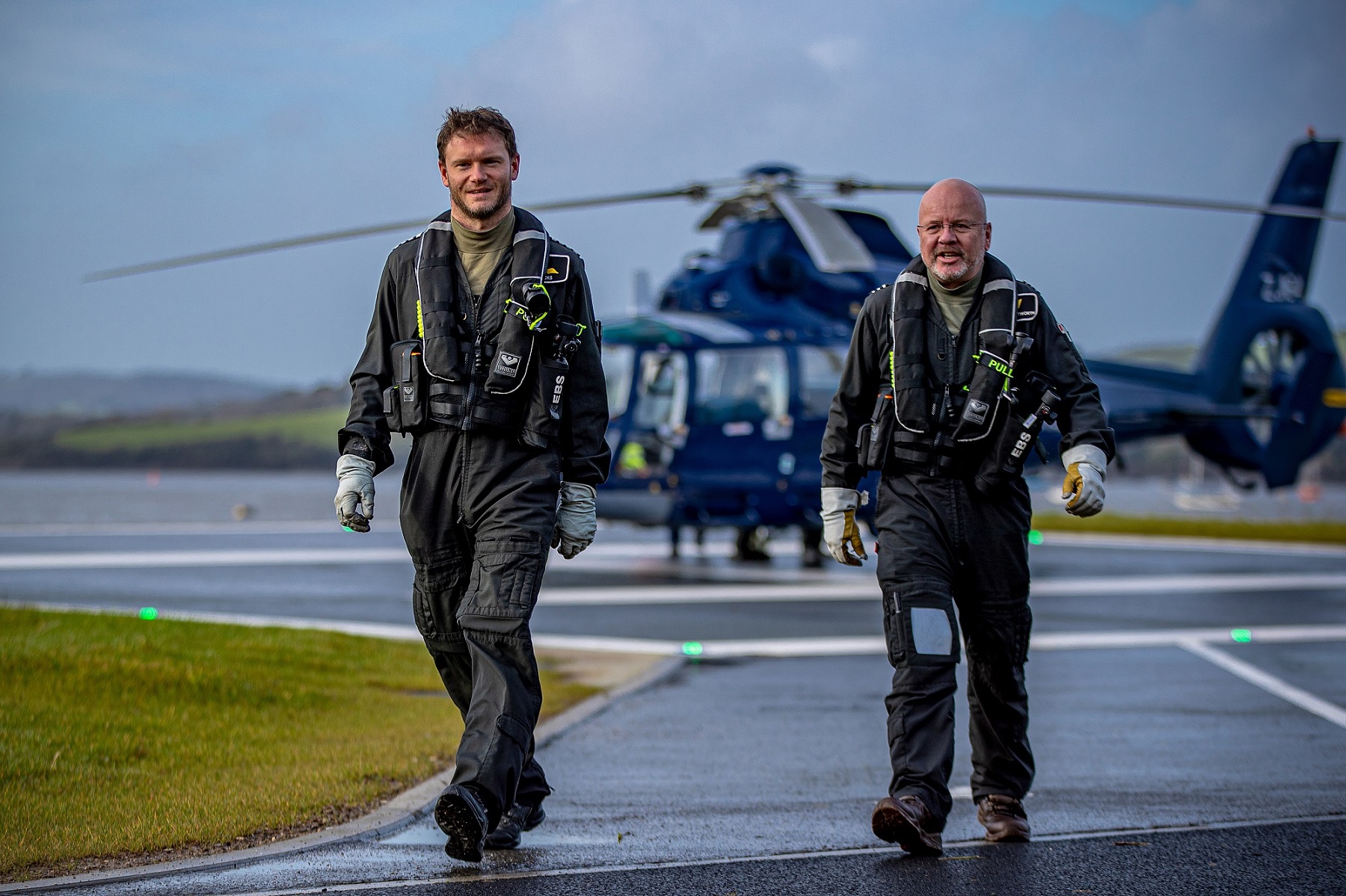 Personnel walking across the helipad at the new Helicopter Operating Facility at HMNB Devonport