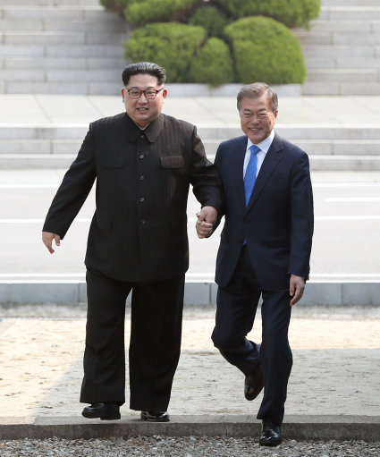 President Moon grips Kim Jong Un's hand (Image: PA).