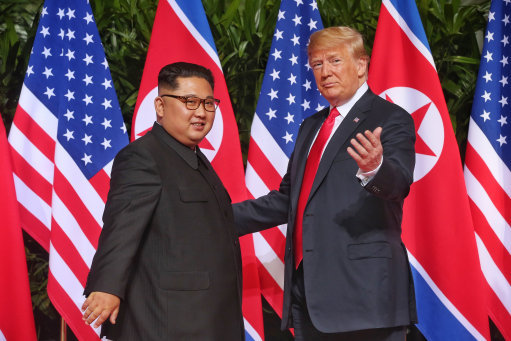 The two leaders meet in front of US and North Korean flags (Picture: PA).
