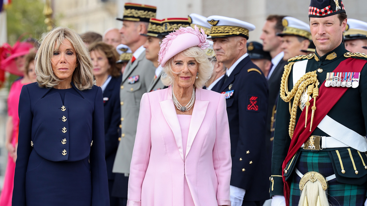 Queen Camilla (right) and Brigitte Macron pictured in front of the guard of honour at the ceremonial welcome at the Arc de Triomphe (Picture: PA Media).