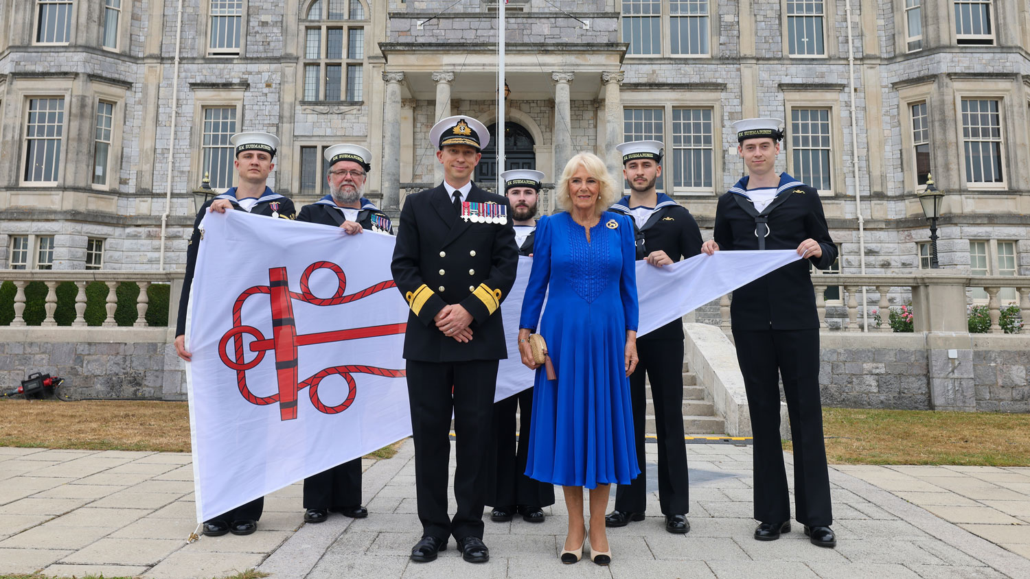 Queen Camilla is formally presented with a burgee pennant by Rear Admiral Andy Perks, Head of the Submarine Service 2 CREDT Royal Navy
