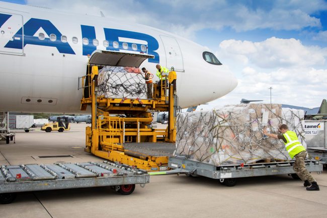 RAF Logistics Team loading aid bound for Nepal into a civilian charter A330 aircraft at RAF Brize Norton