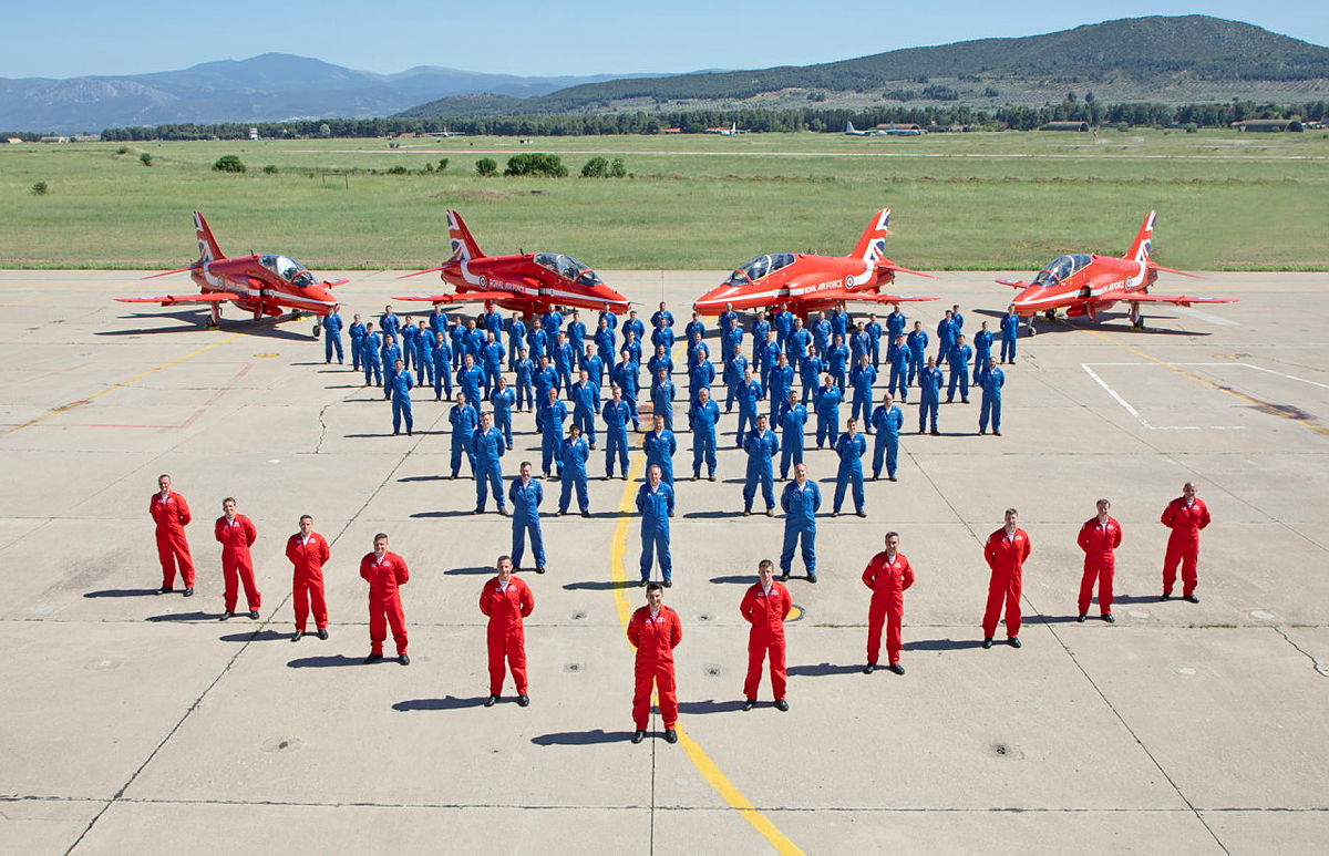 RAF Red Arrow planes, pilots and ground crew shown on a runway