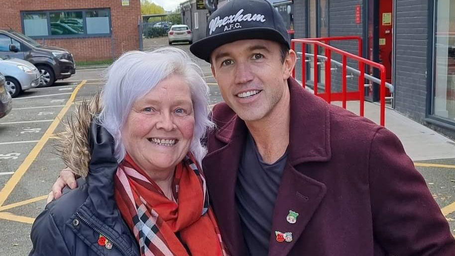 Rob McElhenney and Gill Roberts pose wearing their Wrexham AFC RBL poppy pins at the ground CREDIT Royal British Legion