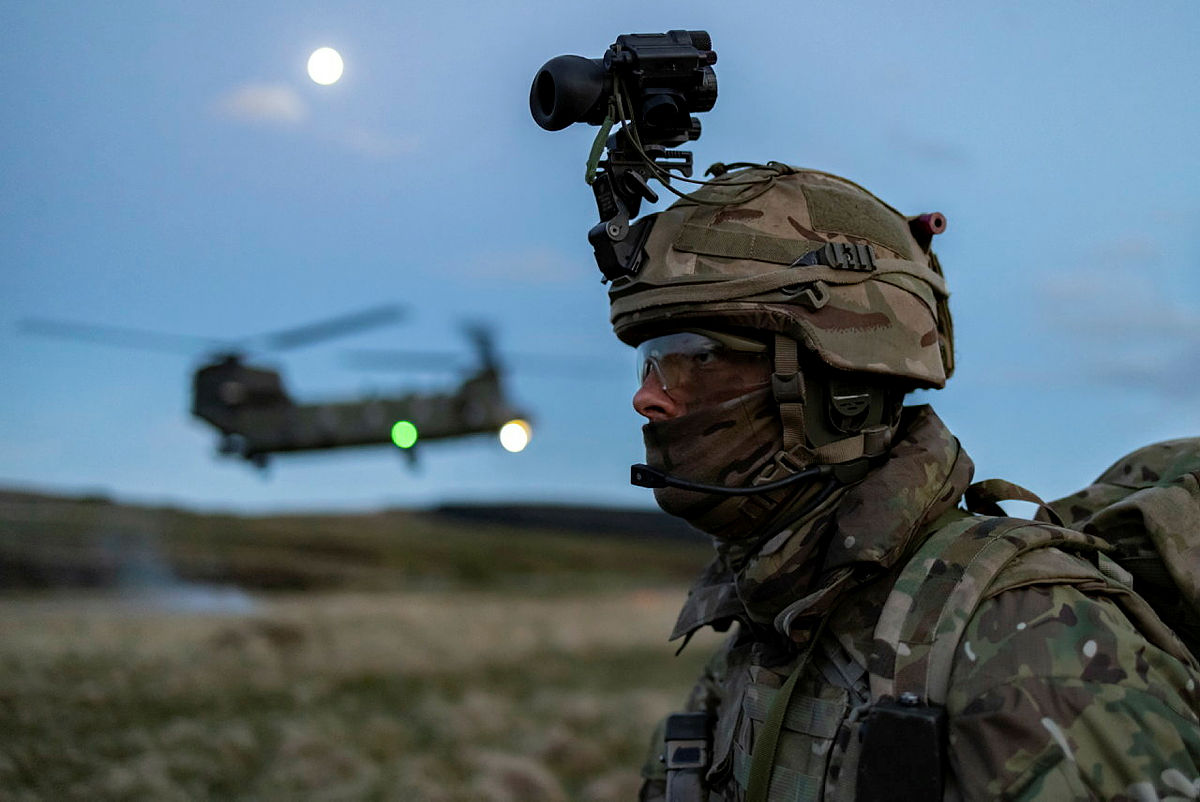 Royal Marine Commando with RAF Chinook hovering in the background