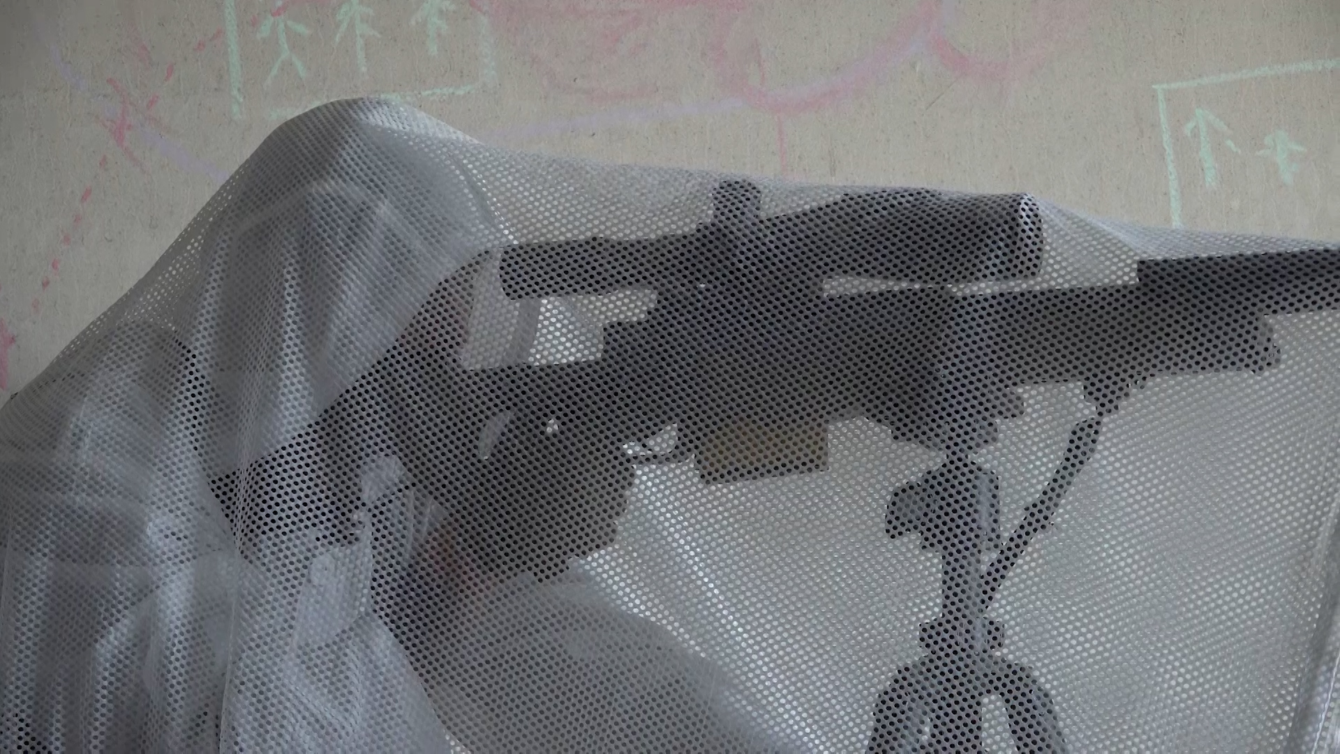The sniper has covered himself in fabric mesh to avoid detection from outside the building