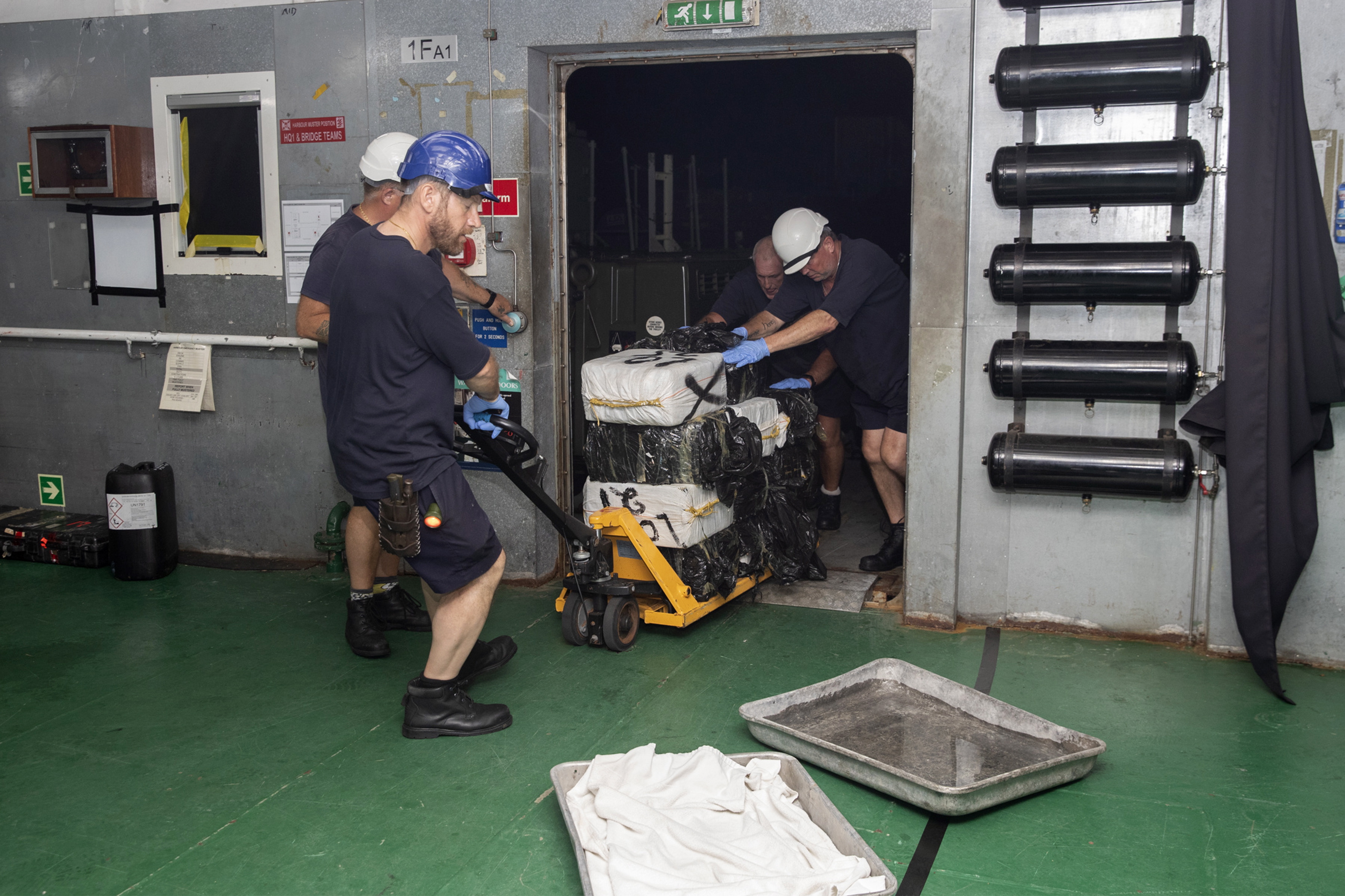Royal Navy personnel handling cocaine after seizing an estimated £81m worth in the Caribbean Sea