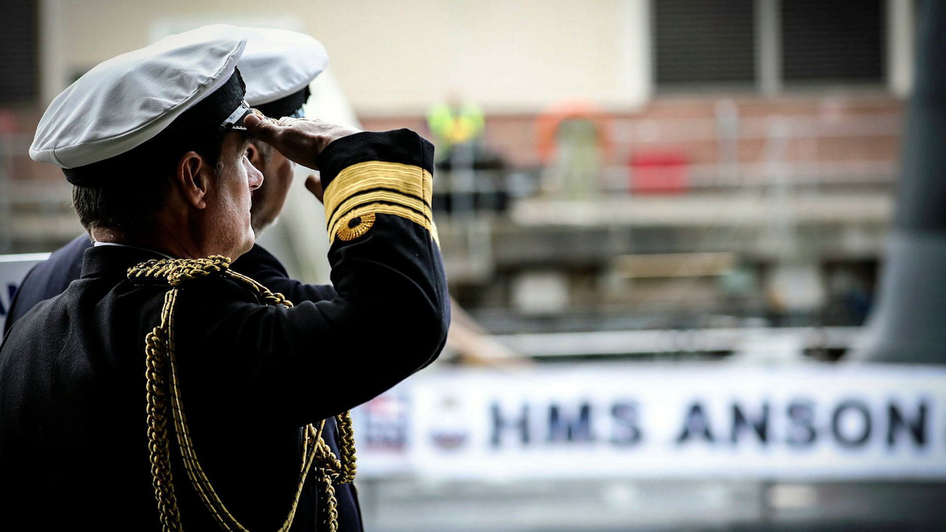 Royal Navy personnel salute during submarine HMS Anson's commissioning ceremony