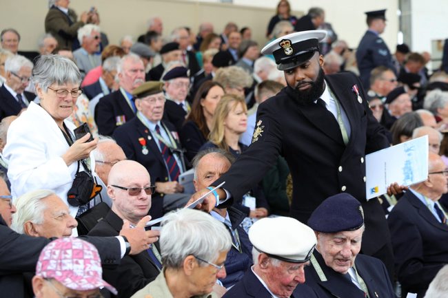 Royal Navy personnel hand out D-Day commemoration programmes to veterans in Portsmouth (Picture: MOD).