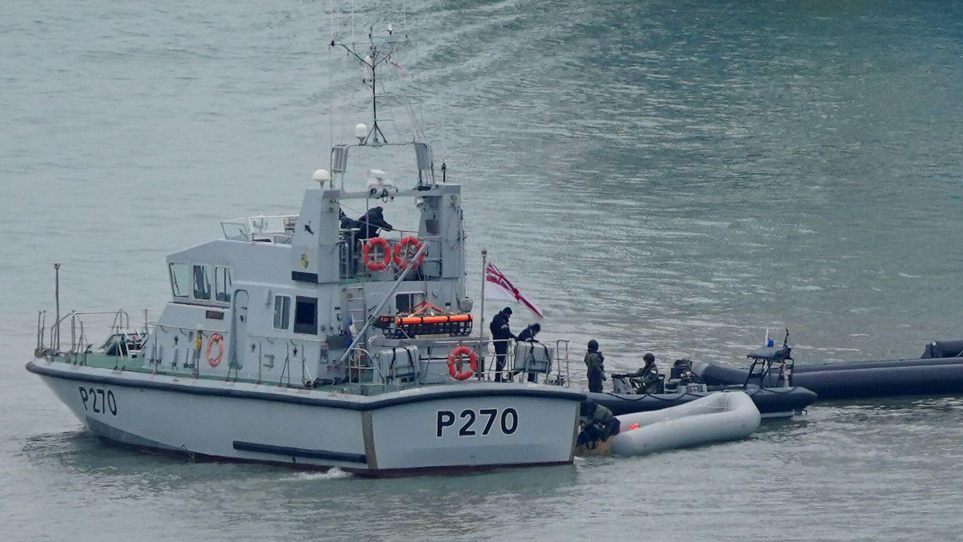 A Royal Navy vessel tows boats, thought to have been used by migrants, into Dover, Kent 