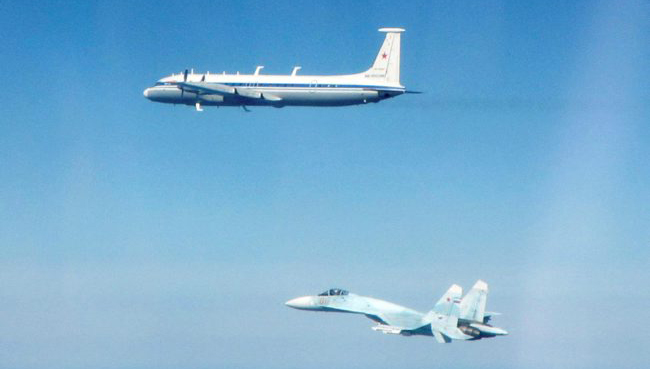 Russian Ilyushin Il-22 Bizon and a SU-27 Flanker aircraft, flying along the Baltic coast