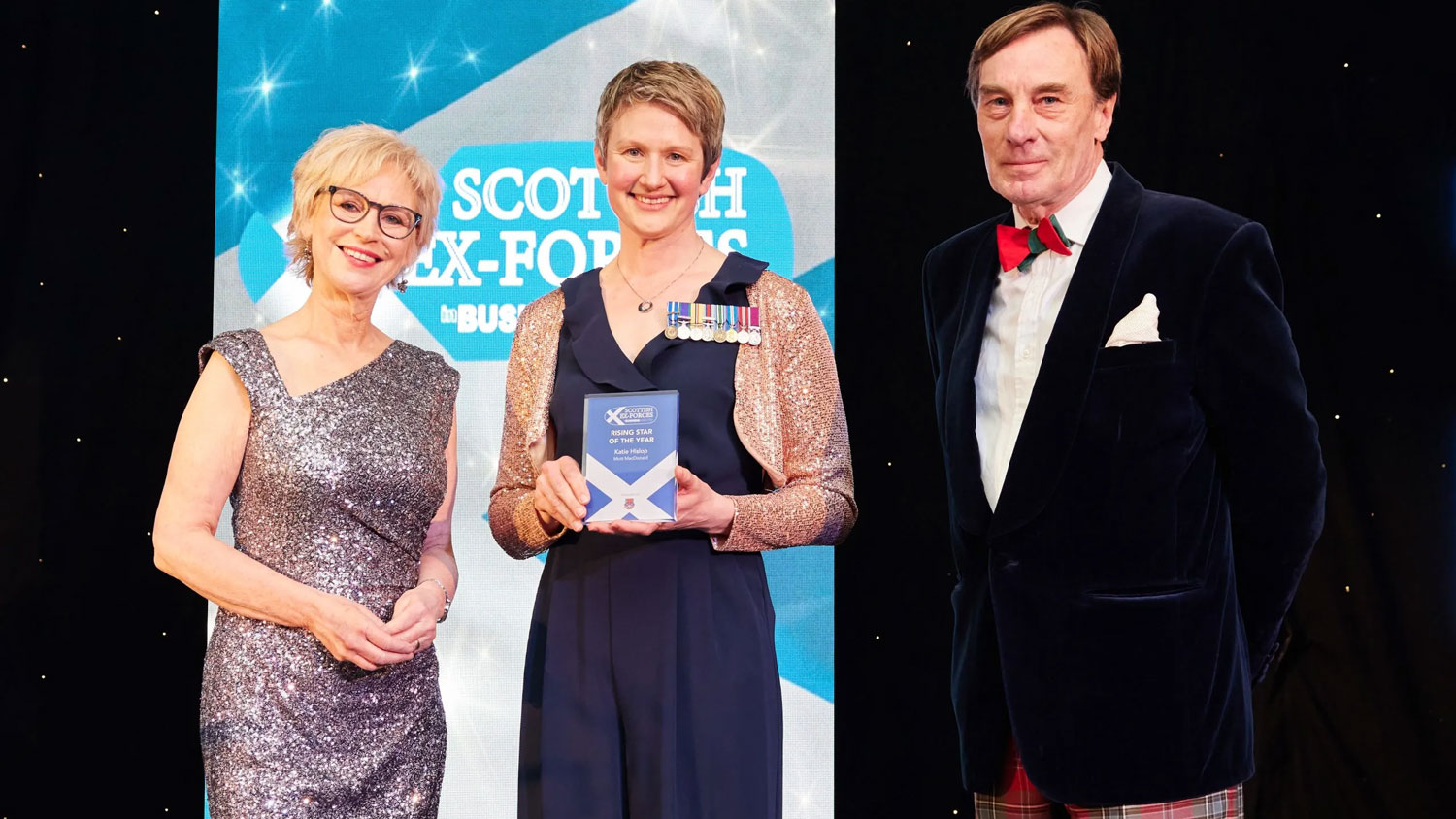 Sally Magnusson, left and Jon Strickland of The MacRobert Trust, right, present Katie Hislop of Mott MacDonald, centre, the Rising Star of the Year award in 2023 CREDIT Ex-Forces in Business Awards